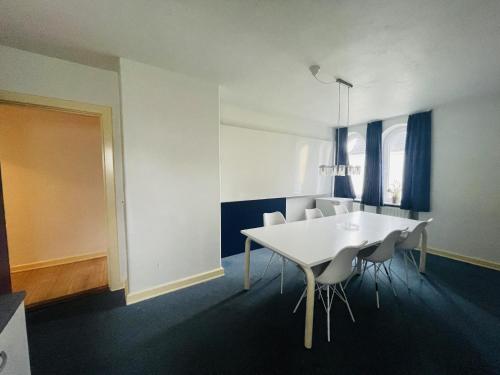 a dining room with a white table and chairs at aday - Spacious and beautiful apartment in the center of Frederikshavn in Frederikshavn