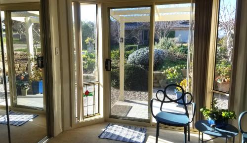 a screened in porch with two chairs and sliding glass doors at Blue Wren Retreat in Orange