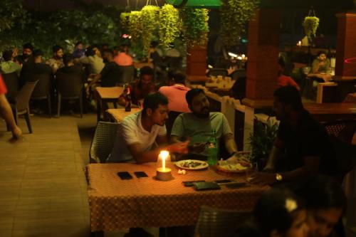 a group of men sitting at a table with a candle at SkyLounge Residency in Trivandrum