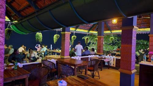 a group of people sitting at tables in a restaurant at SkyLounge Residency in Trivandrum