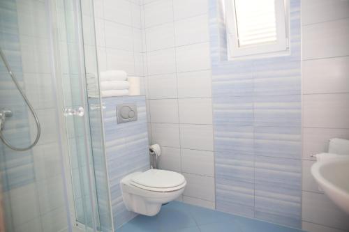 a white bathroom with a toilet and a sink at Apartments Barbati in Novalja