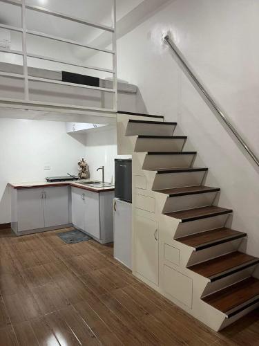 a staircase in a room with a kitchen at ARJ Property Rental Family Rooms in Bauang