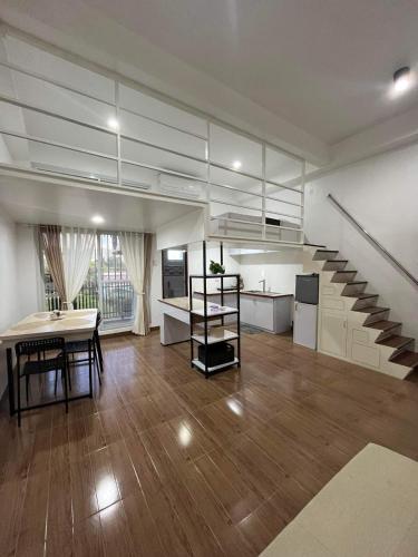 una gran sala de estar con una escalera y una mesa en ARJ Property Rental Family Rooms, en Bauang