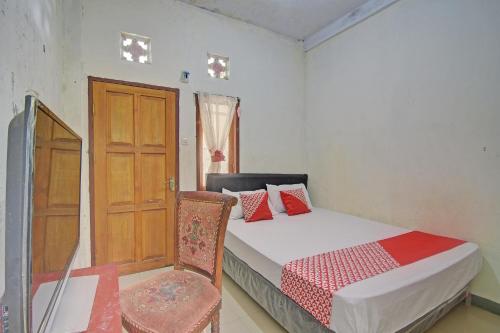 sypialnia z łóżkiem, drzwiami i krzesłem w obiekcie SPOT ON 92281 Susupuan Kost w mieście Tondano