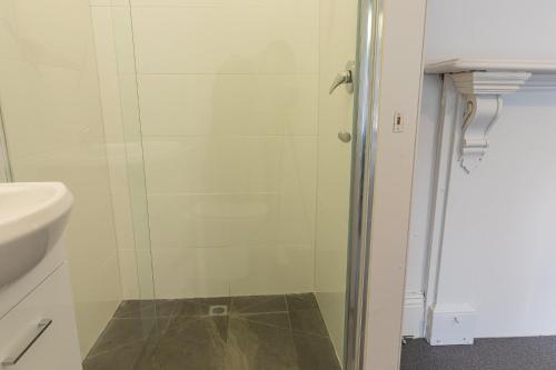 a bathroom with a glass shower with a sink at 50 Green St Windsor in Melbourne
