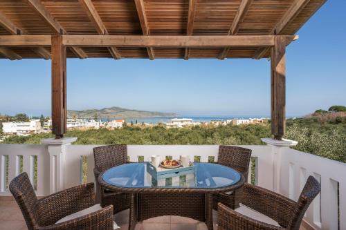 un patio con sillas y una mesa con vistas al océano en Casa de philippe with unique Seaview 2' from beach, en Ayiá