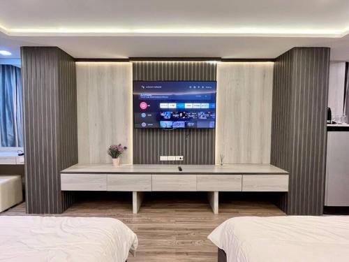 1 dormitorio con TV grande en la pared en DiscoveryHome at Pratunam market, en Bangkok