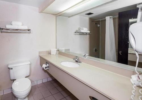 a bathroom with a sink and a toilet and a mirror at MY HOME & SUITES MADISON GA in Madison