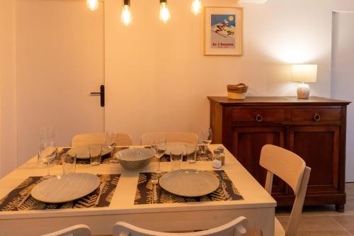 a dining room with a table with plates and chairs at Les appartements de Clélia in Ax-les-Thermes