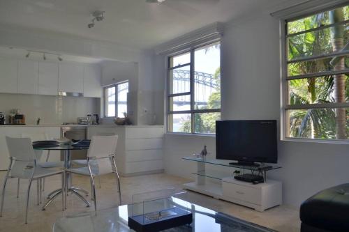 a living room with a table and a tv in it at Harbourside7 - modern 1br unit with fab views in Sydney