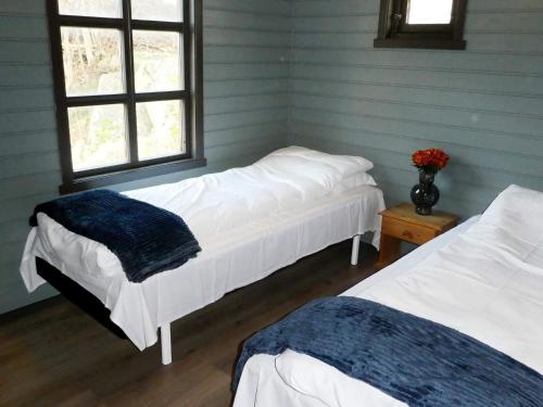 dwa łóżka w pokoju z dwoma oknami w obiekcie Holiday home Selje III w mieście Selje