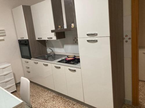 a kitchen with a stove and a white refrigerator at La scaletta sul mare di Pizzo [ WiFi e Disney+ ] in Pizzo