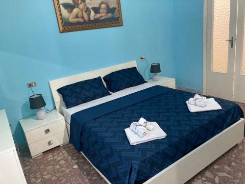 um quarto azul com uma cama com toalhas em La scaletta sul mare di Pizzo [ WiFi e Disney+ ] em Pizzo