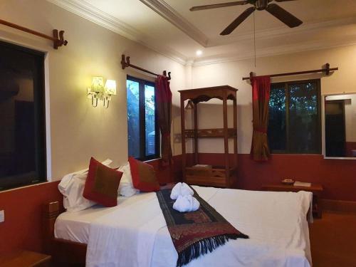 sypialnia z 2 łóżkami i wentylatorem sufitowym w obiekcie Phoumrumduol Bungalow w mieście Kâmpôt