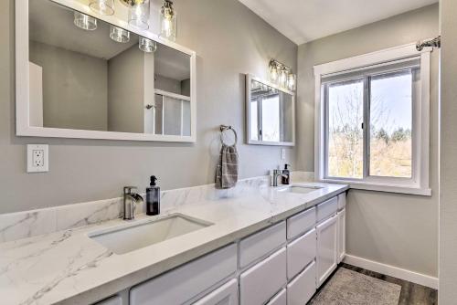 Baño blanco con 2 lavabos y ventana en Fully Remodeled Hillsboro Home with Home Theater!, en Hillsboro