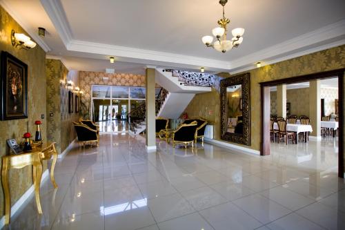a lobby with chairs and tables in a building at Hotel Millenium in Żyraków