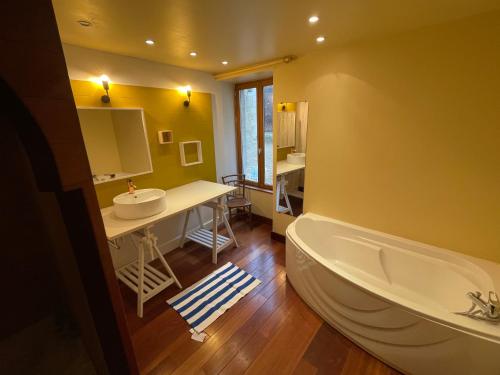 a bathroom with a bath tub and a sink at Maison de charme proche Futuroscope in Bonneuil-Matours