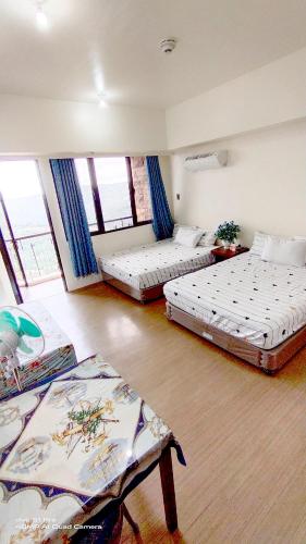 a room with three beds in it with windows at Splendido Tagaytay Taal Lake Staycation Free Parking Netflix No Free Pool in Tagaytay