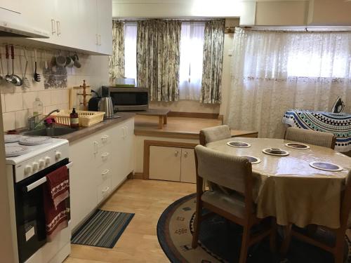a kitchen with a table and a kitchen with a stove at Canaan Homestay in Watsonia North