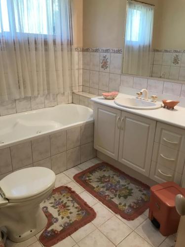 a bathroom with a tub and a toilet and a sink at Canaan Homestay in Watsonia North