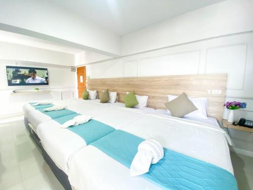 a large white bed with towels on it in a room at 48 Ville Donmuang Airport in Bangkok