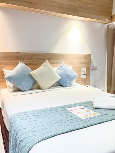 a bedroom with a bed with blue and white pillows at 48 Ville Donmuang Airport in Bangkok