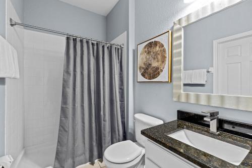 a bathroom with a toilet and a sink at The Wish House, just miles from Disney World in Orlando