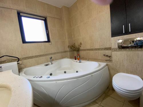a bathroom with a large white tub and a toilet at Penthouse City Centre in Iaşi