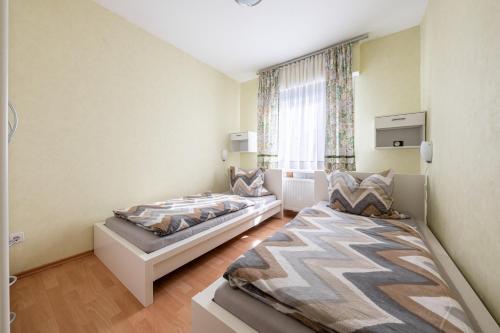 a bedroom with two beds and a window at Ferienhaus Hunsrückliebe in Liederbach