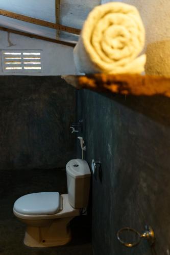 a bathroom with a toilet and a towel at Little Bay Arugam Bay in Arugam Bay