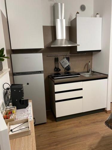 a kitchen with white cabinets and a stove top oven at M&G holiday house in Matera