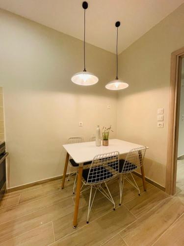 a dining room with a table and chairs and lights at CASA MILITOU-NEA FILADELFIA in Athens