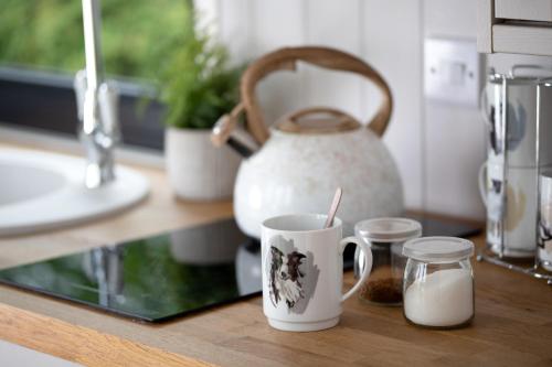 a counter with two coffee cups and a tea kettle at Ribble Valley Retreat in Langho