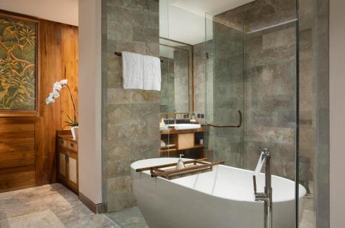 a bathroom with a bath tub and a sink at Adiwana Suweta in Ubud