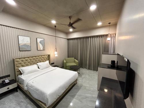 a bedroom with a bed and a chair in it at Apricot Motera in Ahmedabad