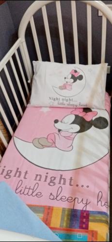 a crib with a blanket and a pillow with a sign on it at MAGNA GRECIA SEA HOME in Torre Canne
