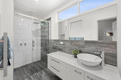 a white bathroom with a sink and a shower at Boutique Heritage listed Studios On Ryrie st Geelong CBD in Geelong