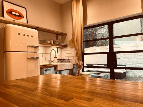cocina con mesa de madera y nevera en NEW! Luxury 1 bed garden apartment Camden Town, en Londres