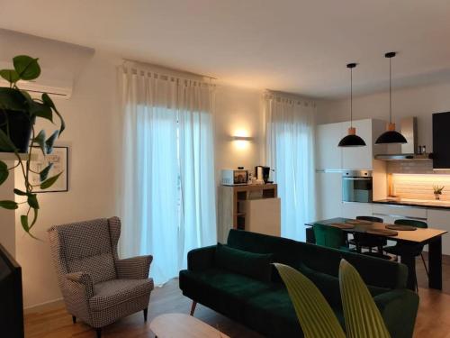een woonkamer met een groene bank en een tafel bij B&B Tanto Piacere Taranto in Taranto
