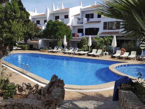 a large swimming pool in front of a hotel at Modernes Apartment mit traumhaftem Blick Vistamar3 in Cala'n Porter