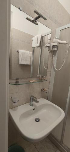 bagno con lavandino, specchio e asciugamani di Hotel Mistral a Milano