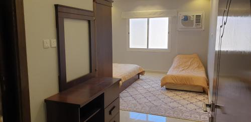 a small bedroom with a mirror and a bed at مزرعة الكرم الحاتمي in Ash Shafa