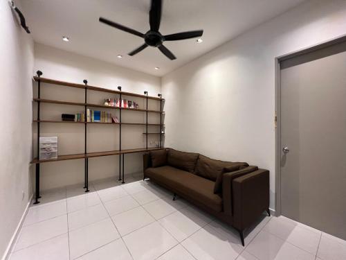 a living room with a couch and a ceiling fan at Jenjarom Cozy House FREE PARKING in Jenjarum