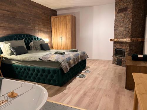 a bedroom with a green bed and a fireplace at Green Home in Miercurea-Ciuc