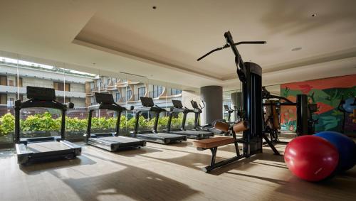 a gym with a row of treadmills and machines at PARKROYAL Langkawi Resort in Pantai Cenang