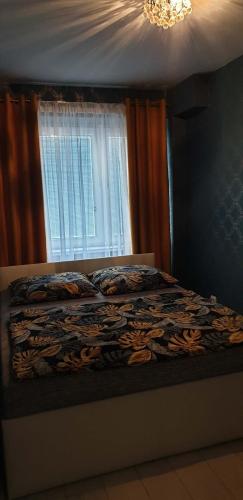 um quarto com uma cama grande e uma janela em APARTAMENT 2+2 em Konin