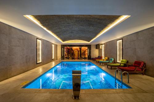 a large swimming pool in a building with a room at The Time Hotel Marina in Istanbul