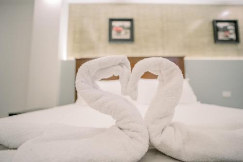 two towels forming the shape of a heart on a bed at Spotlight Hotel in Alaminos