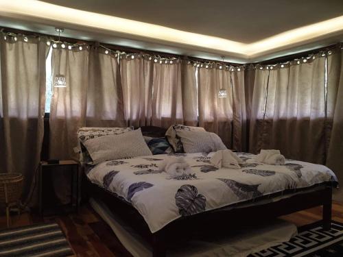 1 dormitorio con 1 cama grande y cortinas en The Farm, en Puerto Princesa City