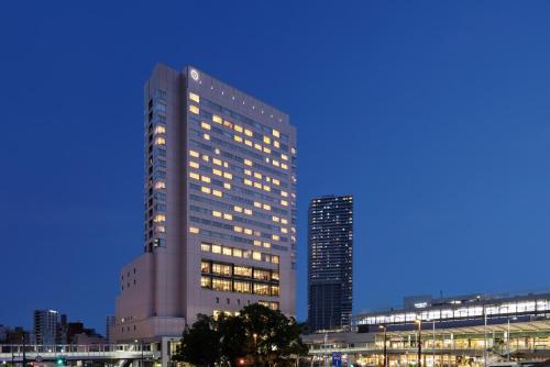 a tall building with lights on in a city at Sheraton Grand Hiroshima Hotel in Hiroshima
